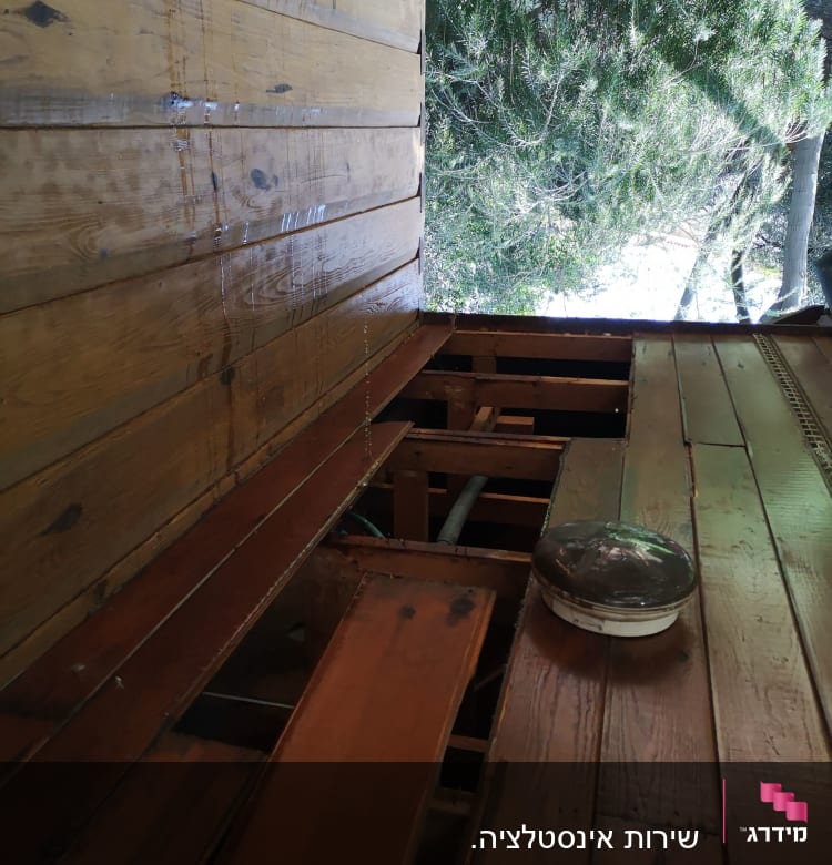 צינורות מתחת לרצפת עץ עם לוח עץ פתוח